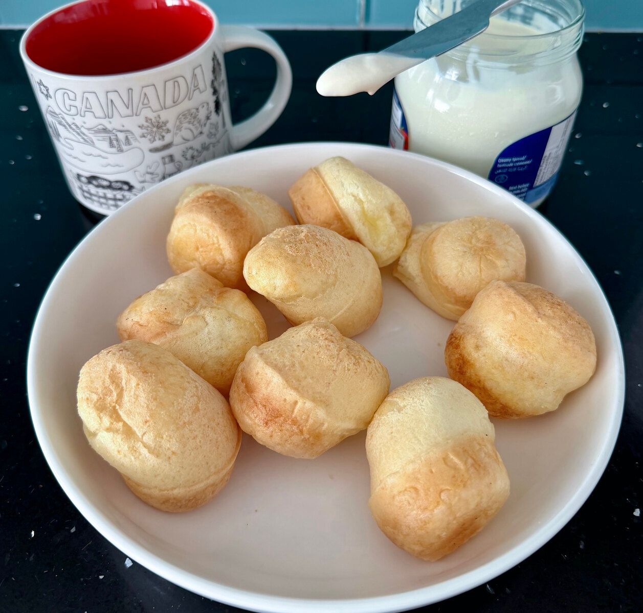 Freshly baked Brazilian cheese bread rolls on a striped cloth