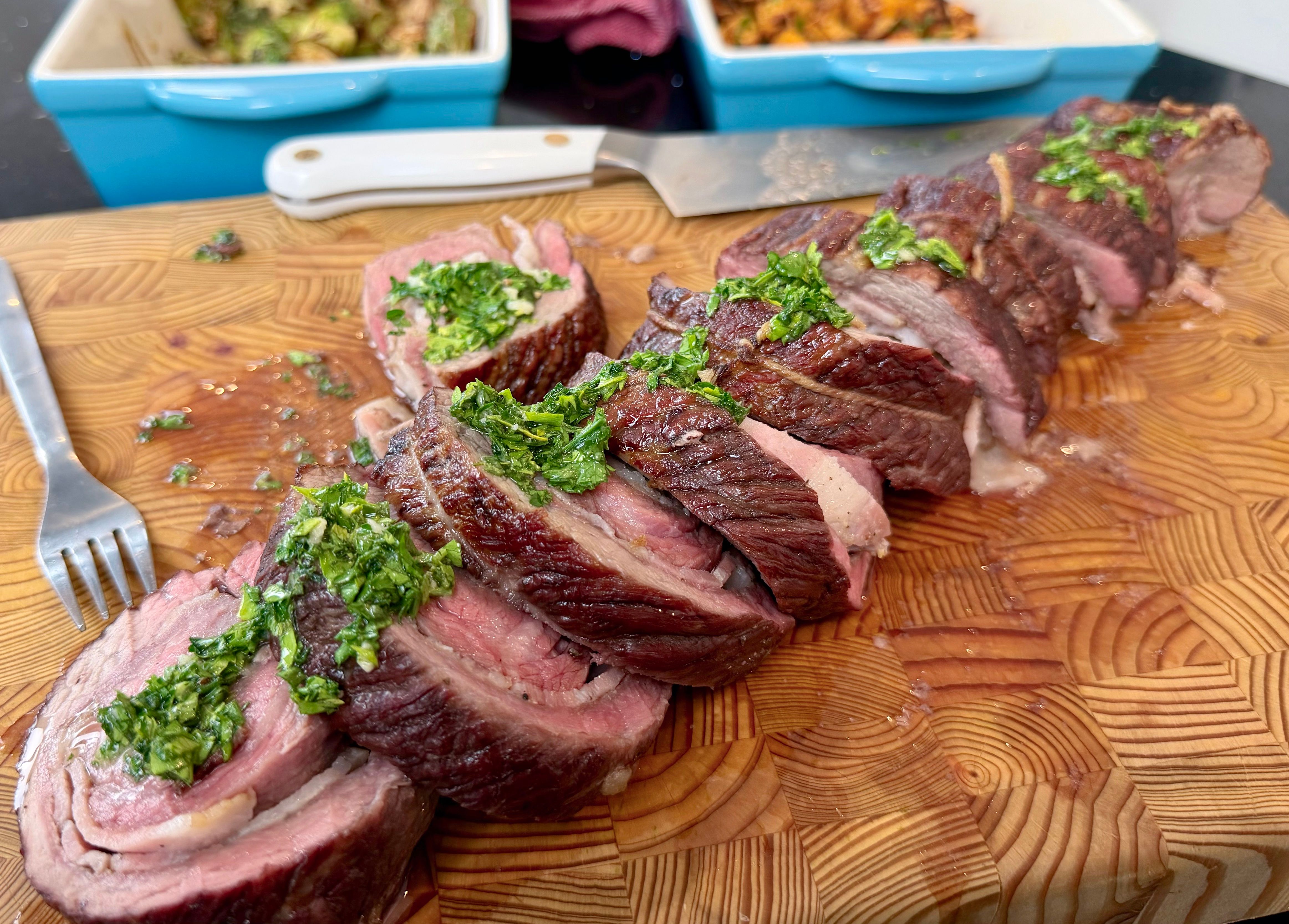 Sliced bacon-stuffed bottom sirloin cap drizzled with green herb dressing